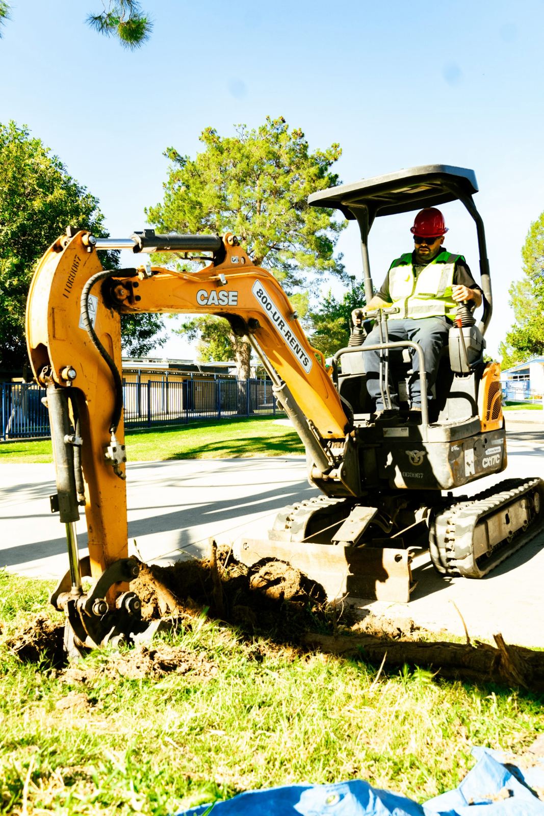 SpeeDee Drains operator running a mini excavator to access a broken sewer line in Fullerton, CA